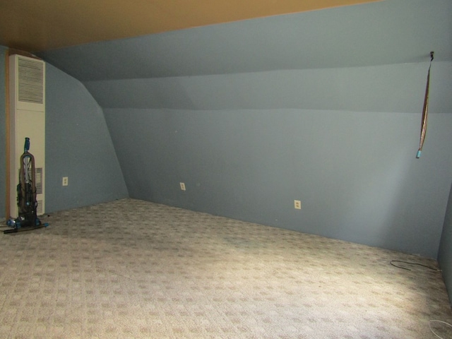 bonus room with carpet floors and vaulted ceiling