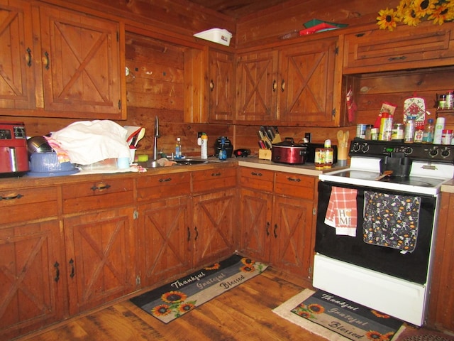 kitchen featuring white range, hardwood / wood-style flooring, and sink