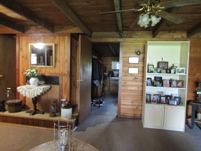 kitchen featuring beamed ceiling, wooden walls, and wood ceiling