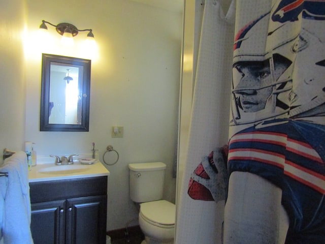 bathroom featuring curtained shower, vanity, and toilet