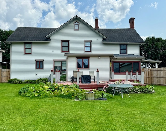 back of house with a lawn, a sunroom, and a wooden deck