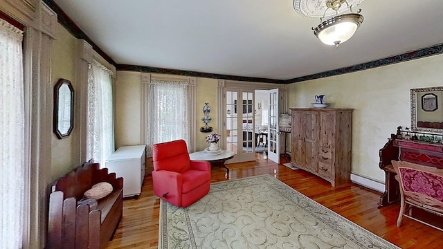 living area featuring wood-type flooring and a baseboard heating unit