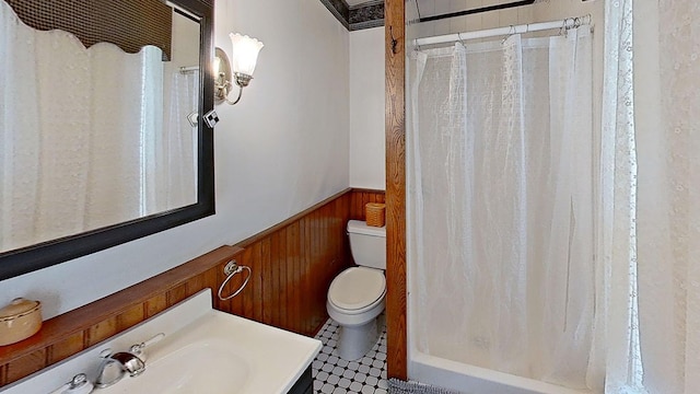 bathroom featuring tile patterned flooring, vanity, wood walls, and toilet