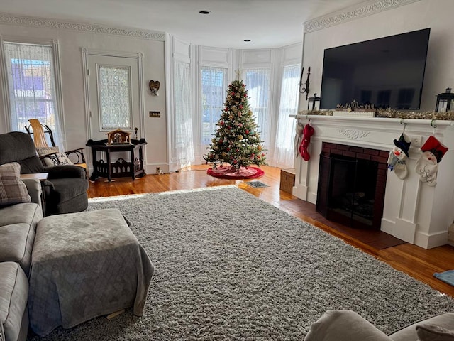 living room featuring wood-type flooring and a brick fireplace