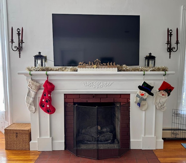 interior details featuring hardwood / wood-style floors and a brick fireplace