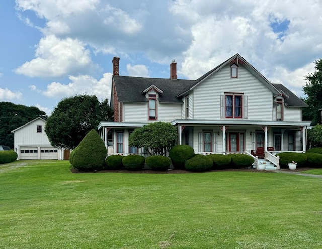 view of front of property with a porch, a garage, an outdoor structure, and a front yard