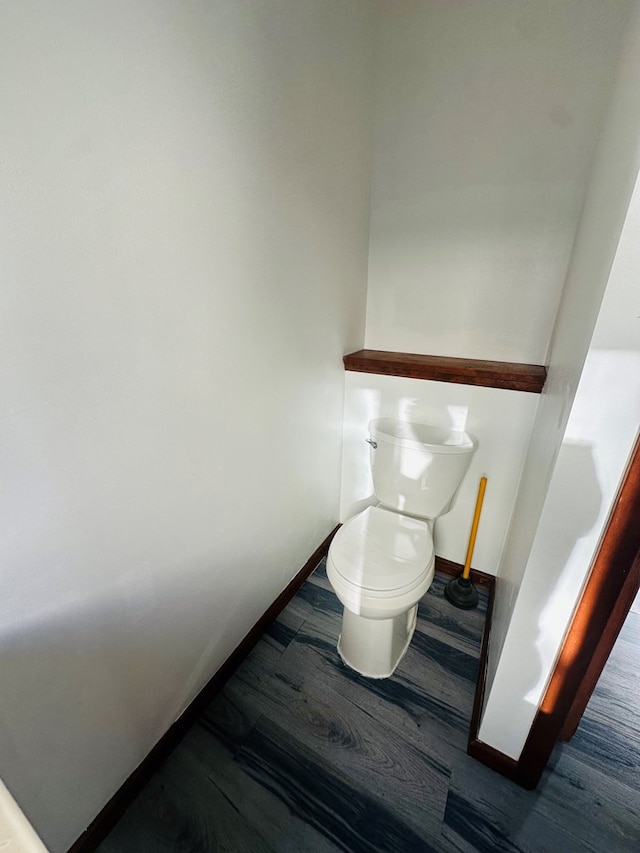 interior space featuring hardwood / wood-style floors and toilet