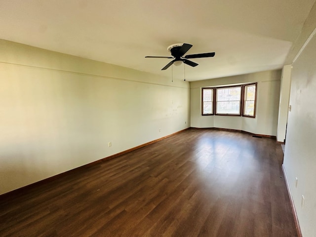 spare room featuring ceiling fan and dark wood-type flooring