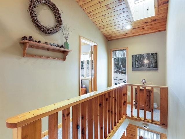 hallway with vaulted ceiling with skylight, wood ceiling, and hardwood / wood-style floors