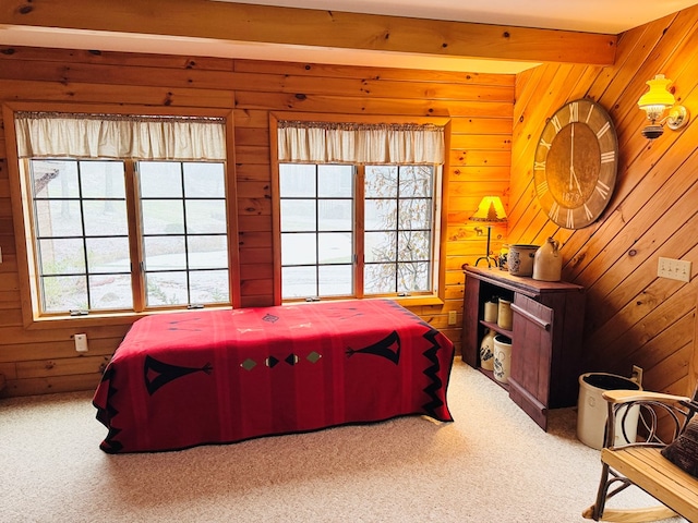 bedroom featuring wooden walls, carpet, and beam ceiling