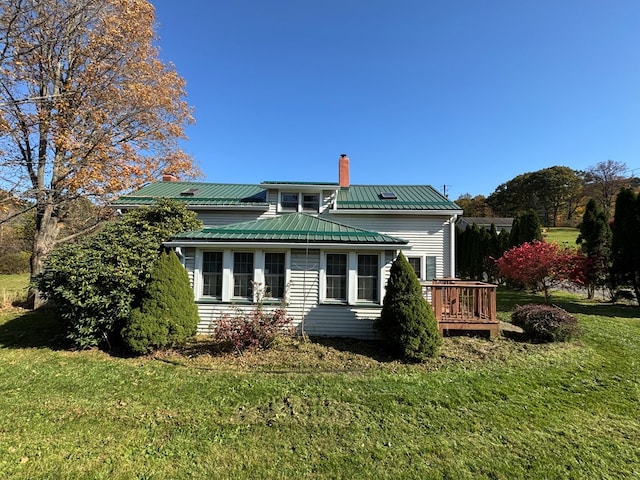 rear view of house with a deck and a lawn