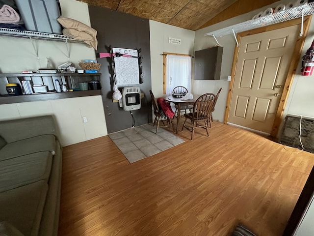 kitchen featuring hardwood / wood-style floors, lofted ceiling, and heating unit