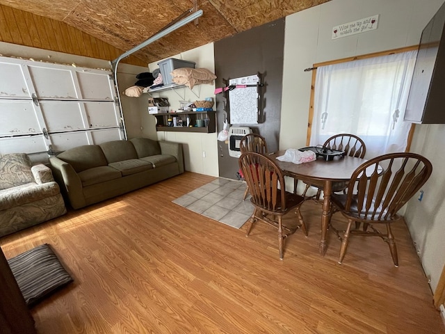 dining room featuring wood-type flooring and vaulted ceiling