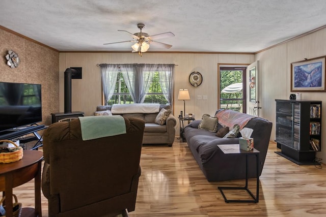 2542 Baldwin Run Rd, Wellsboro, PA 16901 - living area with ornamental molding, a wood stove, a ceiling fan, a textured ceiling, and light wood-style flooring