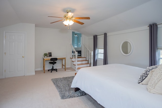 carpeted bedroom with ceiling fan, baseboards, and lofted ceiling