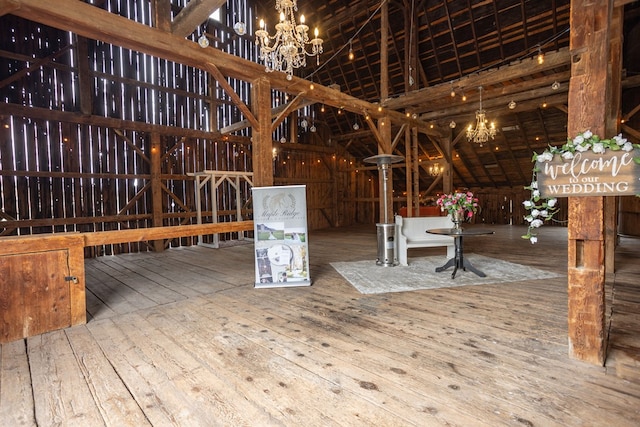 interior space with a chandelier, hardwood / wood-style floors, and vaulted ceiling