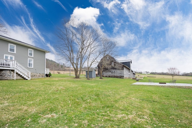 view of yard with an outdoor structure and stairs