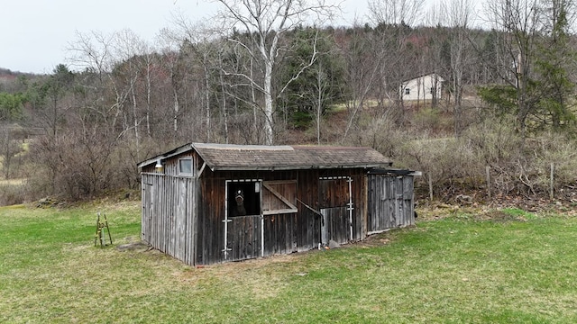 view of outbuilding with an outbuilding and a wooded view