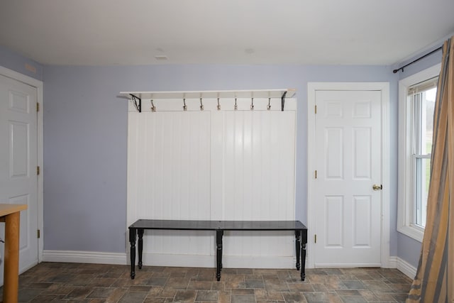 mudroom featuring stone finish flooring and baseboards