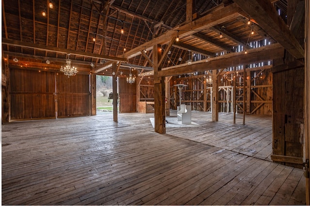 misc room with high vaulted ceiling, a notable chandelier, and hardwood / wood-style flooring