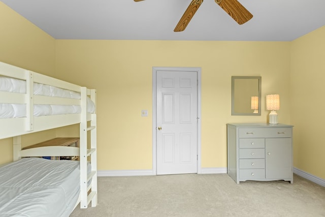 bedroom featuring baseboards, a ceiling fan, and light colored carpet