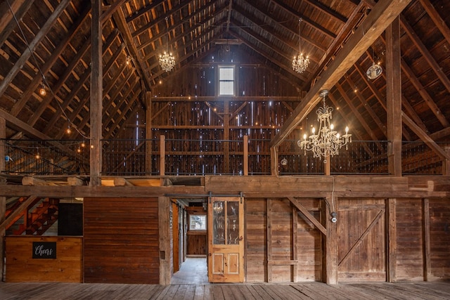 interior space featuring wooden walls, high vaulted ceiling, and a chandelier