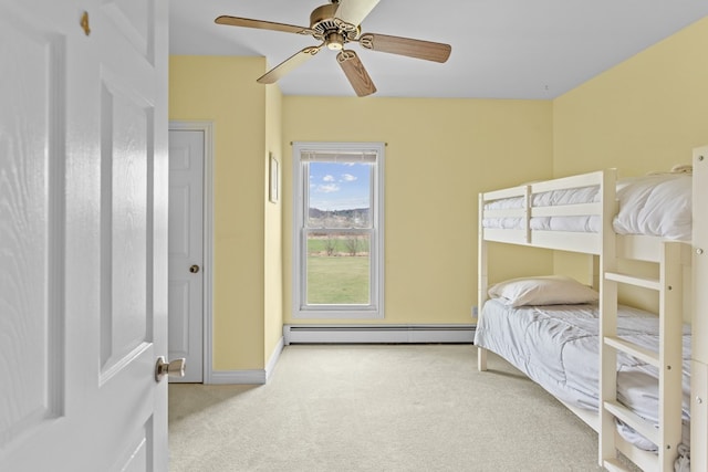 carpeted bedroom featuring a baseboard radiator, baseboards, and a ceiling fan
