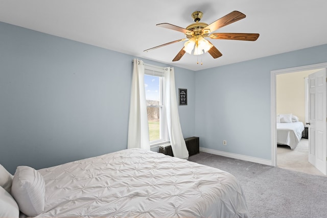 carpeted bedroom with baseboards, radiator, and ceiling fan