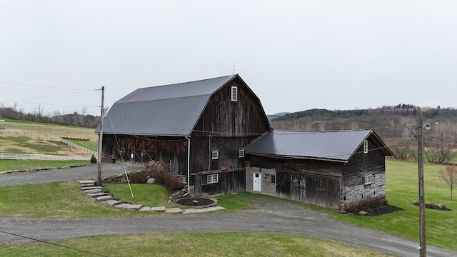 view of barn with a yard and dirt driveway