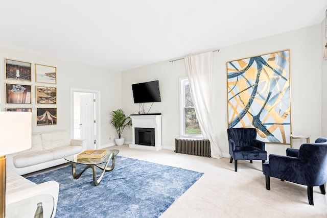 carpeted living area featuring radiator heating unit, baseboards, and a glass covered fireplace