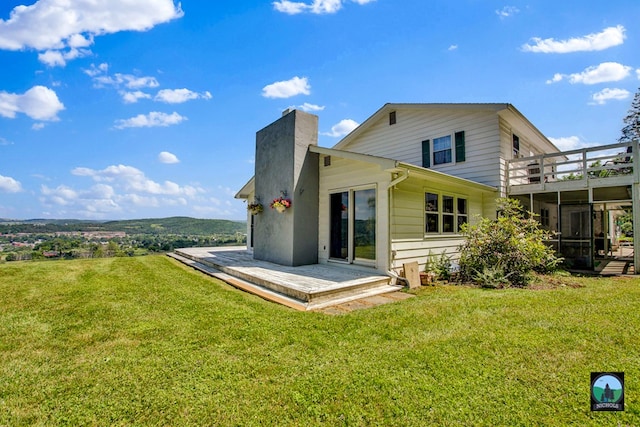 rear view of property with a yard and a wooden deck