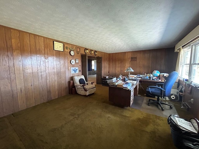 office with carpet flooring, a textured ceiling, and wooden walls