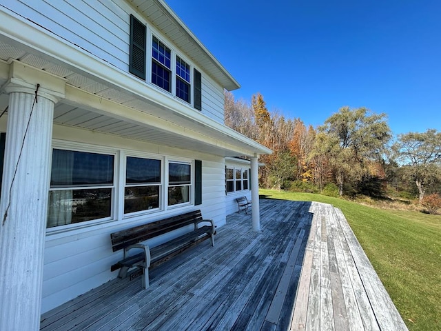 wooden terrace featuring a lawn