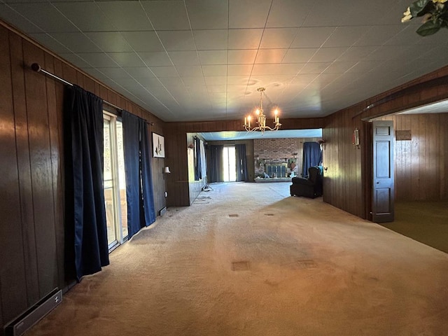 interior space with carpet, wooden walls, and an inviting chandelier