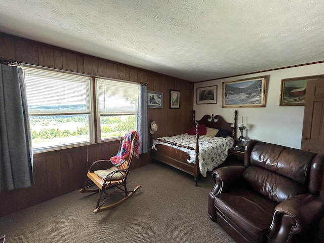 carpeted bedroom with wood walls, a textured ceiling, and multiple windows