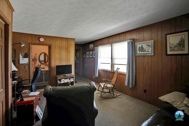 living room with carpet flooring, a textured ceiling, and wooden walls