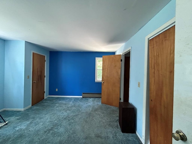 carpeted empty room featuring a baseboard heating unit