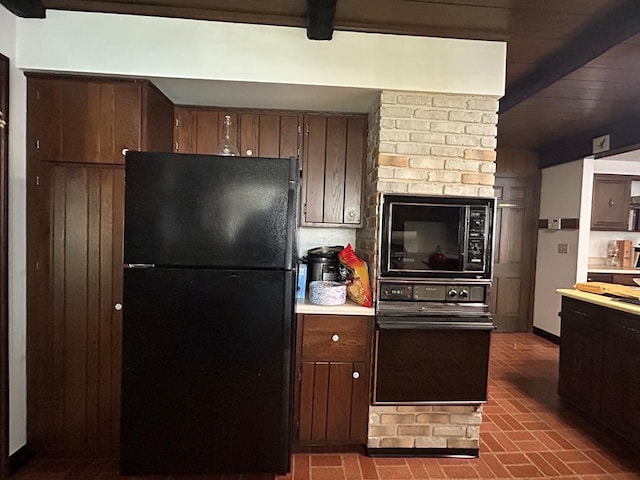 kitchen featuring beam ceiling, dark brown cabinetry, and black appliances