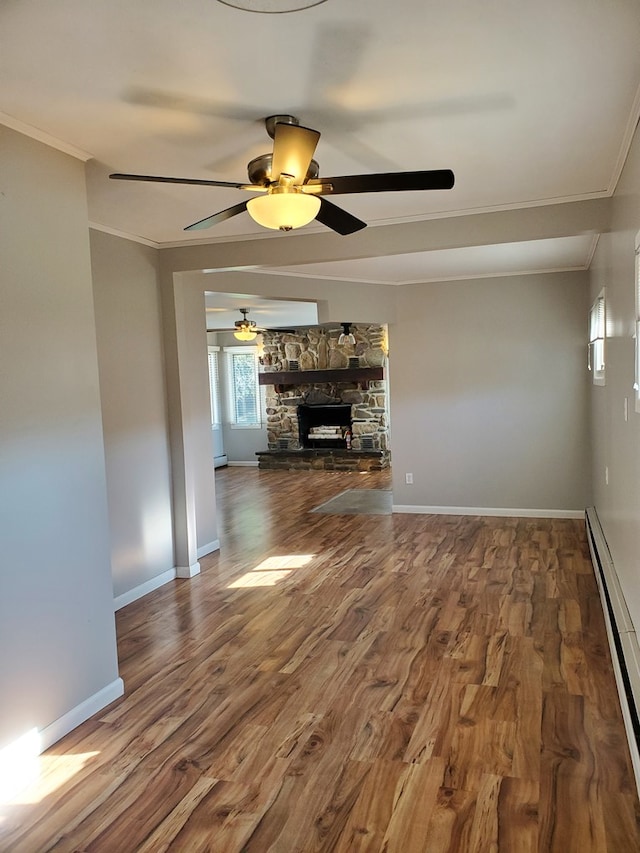 unfurnished living room with a fireplace, hardwood / wood-style floors, a baseboard radiator, and crown molding