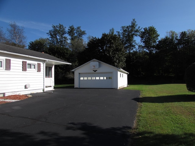 view of property exterior featuring a lawn, a garage, and an outbuilding