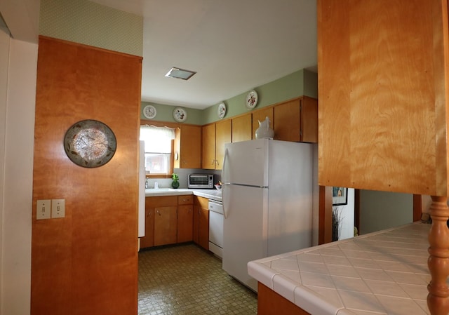 1 Mechanic St, Towanda, PA 18848 - kitchen with white appliances, tile countertops, and brown cabinets