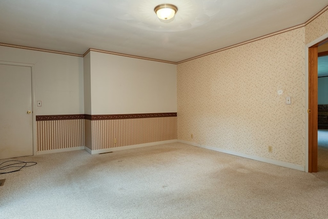 spare room with baseboards, carpet floors, ornamental molding, and wallpapered walls