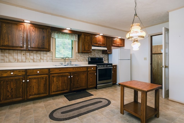 kitchen featuring stainless steel range with gas cooktop, freestanding refrigerator, a sink, light countertops, and under cabinet range hood