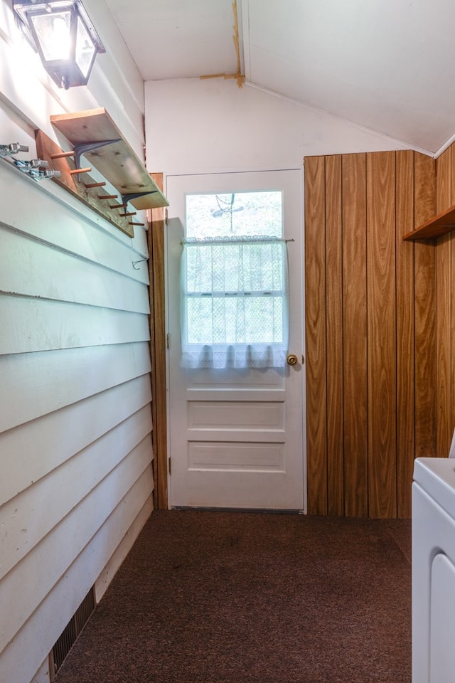 entryway with vaulted ceiling, carpet, and washer / dryer