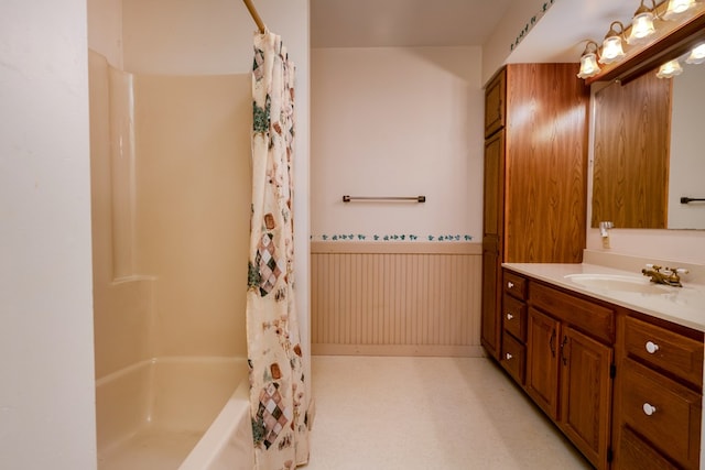 full bath featuring a wainscoted wall, vanity, and shower / tub combo