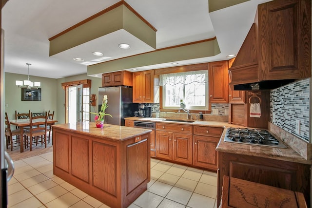 kitchen featuring a center island, tasteful backsplash, a sink, light tile patterned flooring, and appliances with stainless steel finishes