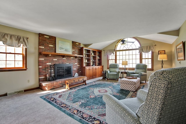 carpeted living room with a brick fireplace, lofted ceiling, visible vents, and baseboards