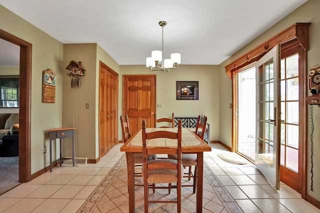 dining area featuring plenty of natural light, baseboards, a notable chandelier, and light tile patterned floors