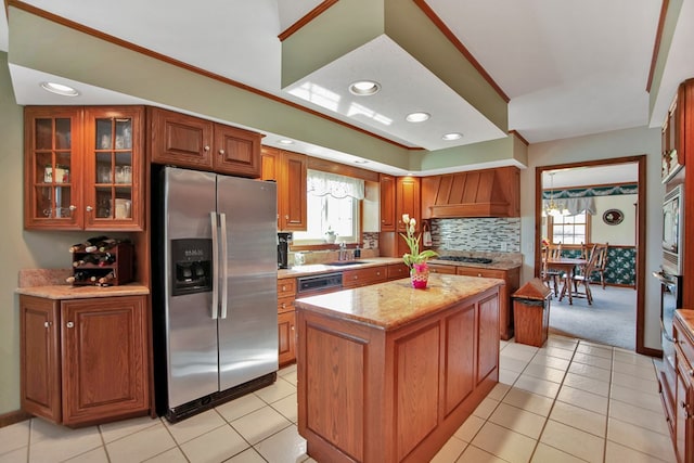 kitchen with a center island, brown cabinets, decorative backsplash, glass insert cabinets, and stainless steel appliances