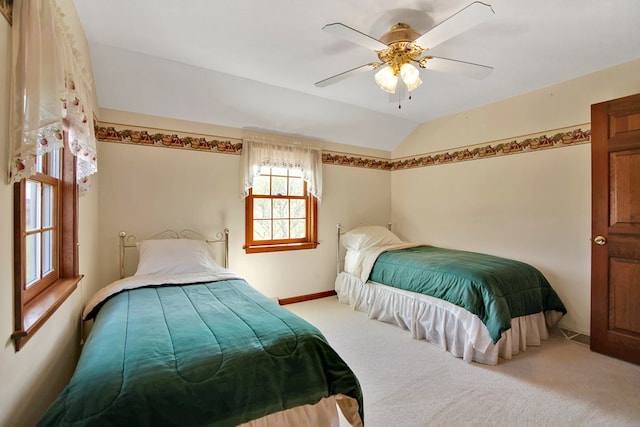 carpeted bedroom with lofted ceiling, baseboards, and ceiling fan